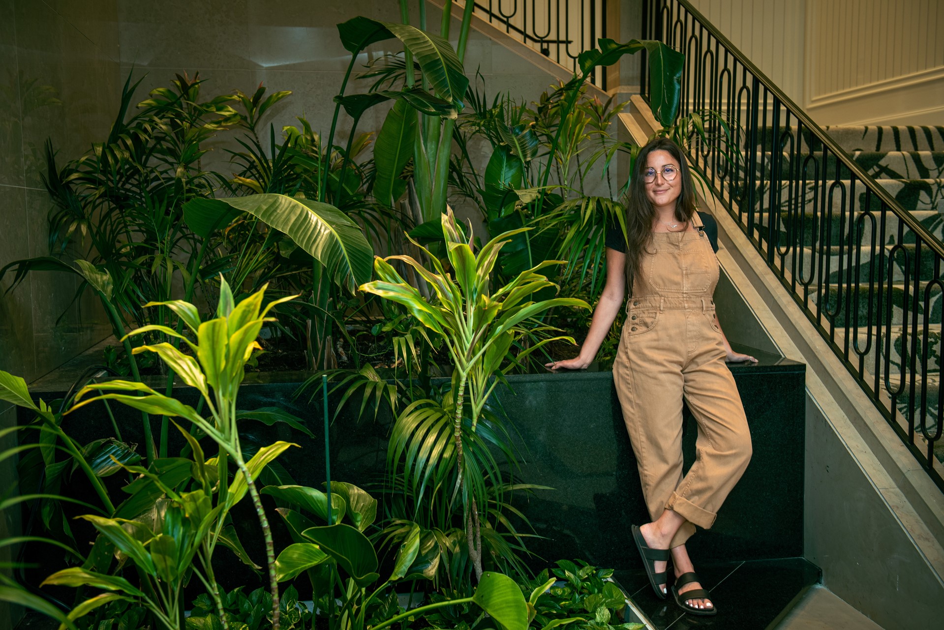 woman standing by lush plants on stairs