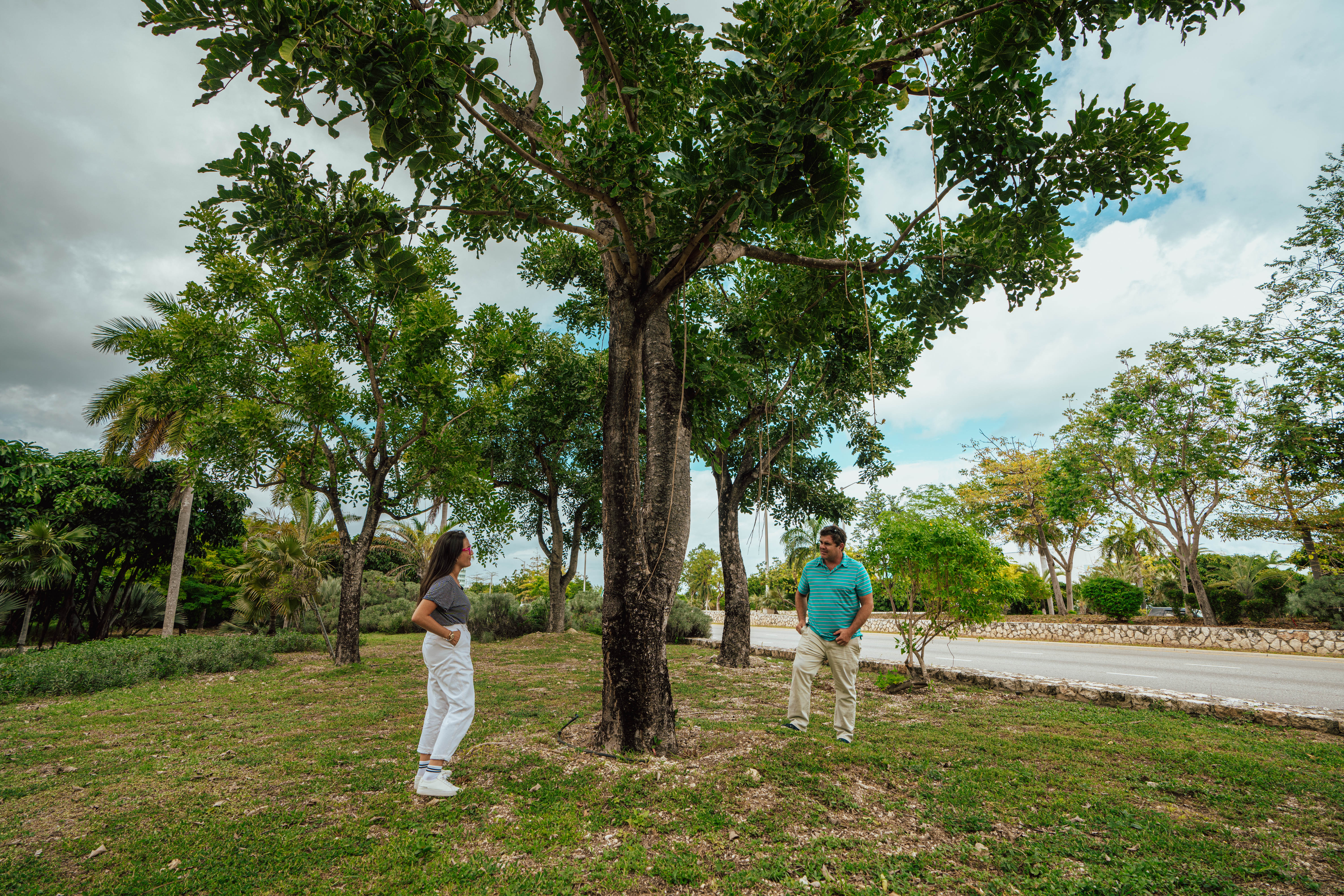 Man and woman stand by tree