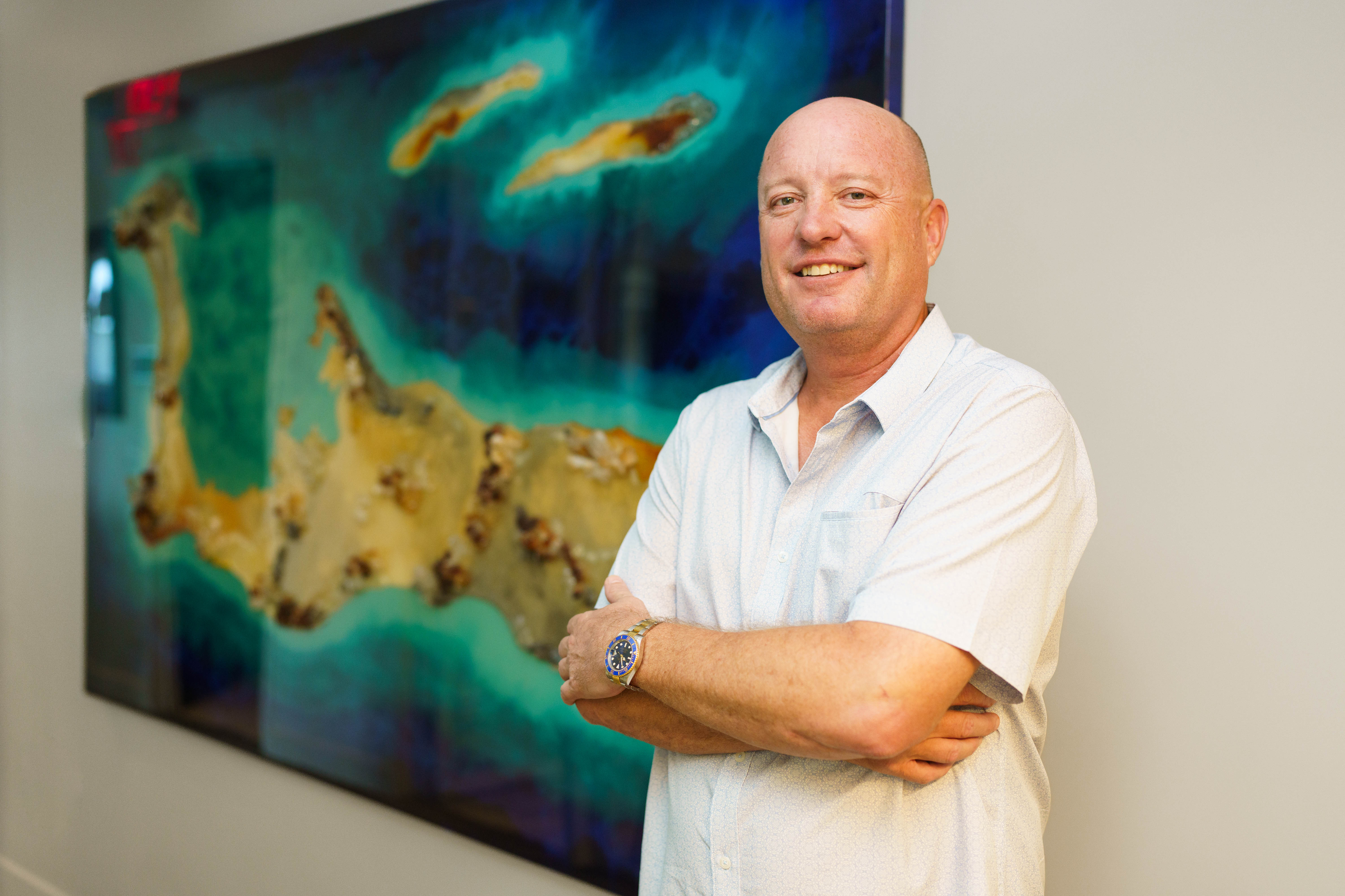 Man smiles in front of picture